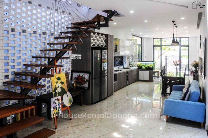 A living room with stairs leading up to a kitchen in Danang, Vietnam.