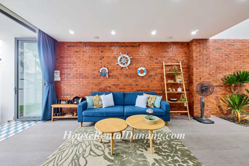A living room in Danang, Vietnam with red brick walls.