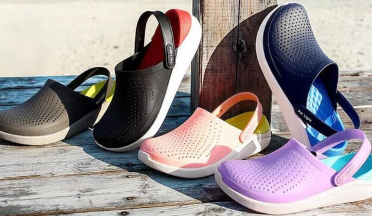 Nhiều đôi Crocs LiteRide nhiều màu xếp trên nền gỗ bên bờ biển
