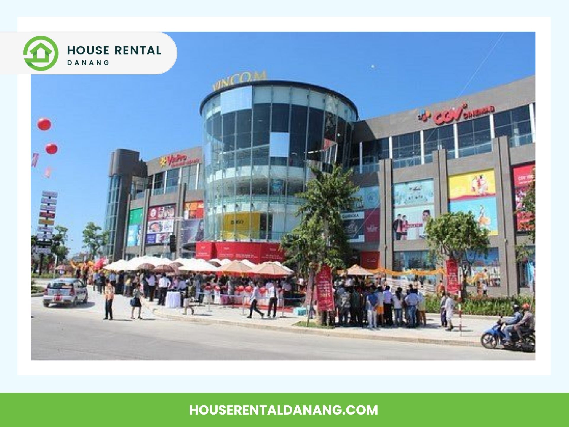 A large commercial building with a "Vincom" sign stands prominently, attracting people gathered under white tents. Various storefronts invite shoppers. The image reads "House Rental Danang" with a website link. Discover one of the best places for shopping in Da Nang!
