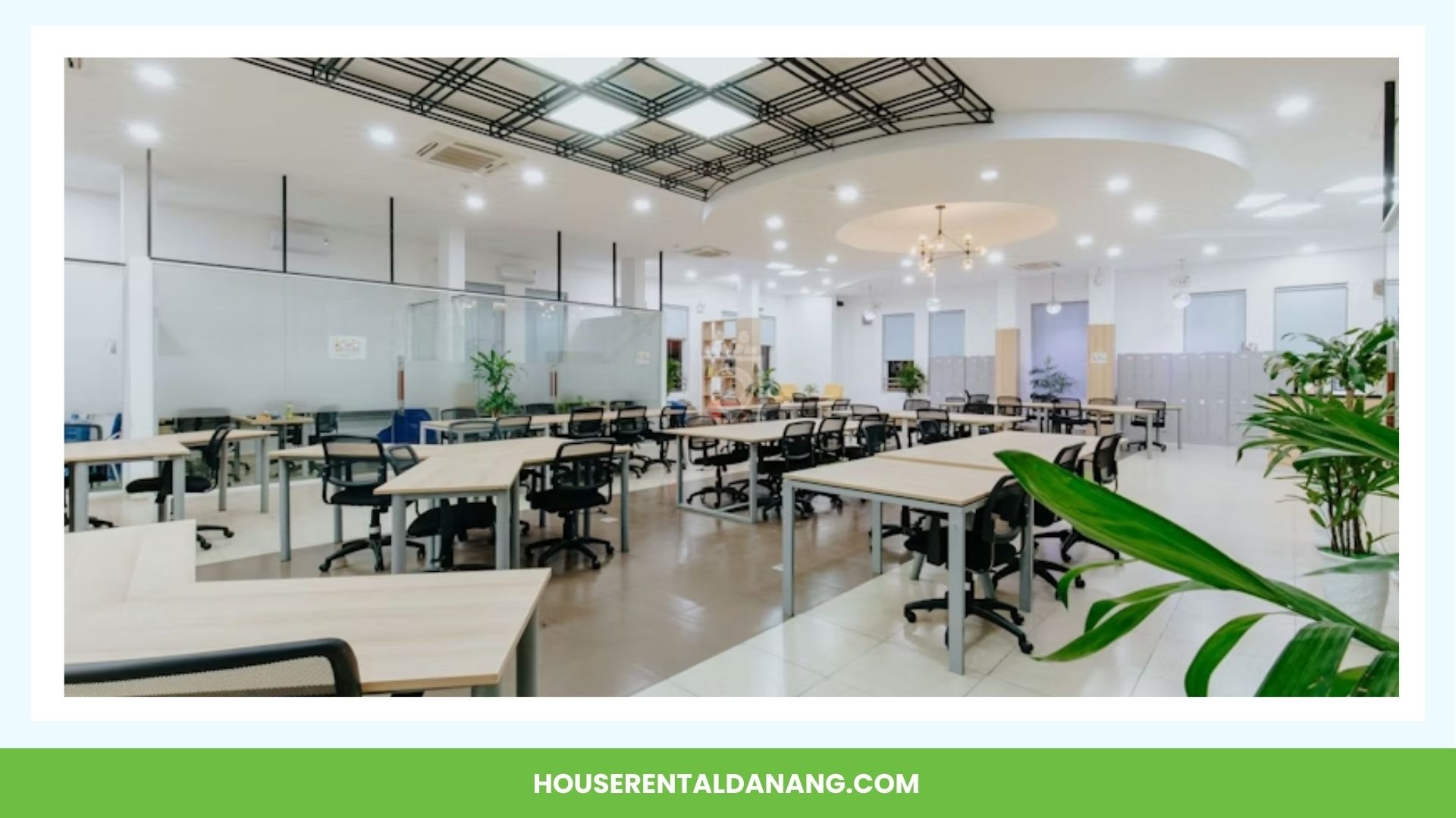 A spacious open-plan office with numerous desks and chairs, modern lighting, potted plants, and a green banner at the bottom that reads "HOUSERENTALDANANG.COM" – the perfect example of coworking spaces in Da Nang.