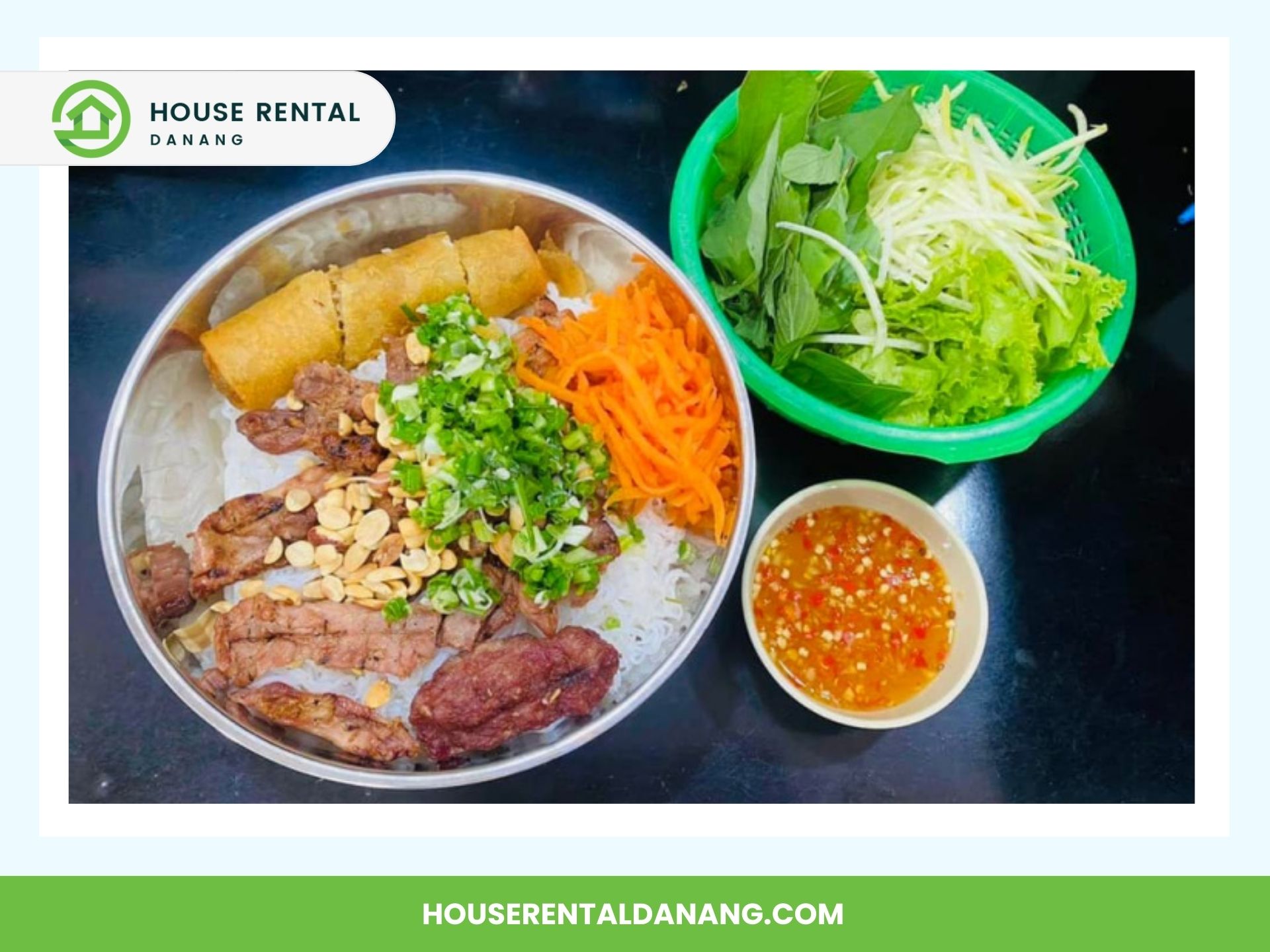 A bowl of grilled meat, noodles, peanuts, vegetables, and egg rolls is accompanied by a green bowl of fresh vegetables and a small bowl of dipping sauce. Branded as "House Rental Danang," it's the perfect meal to enjoy after exploring Con Market.