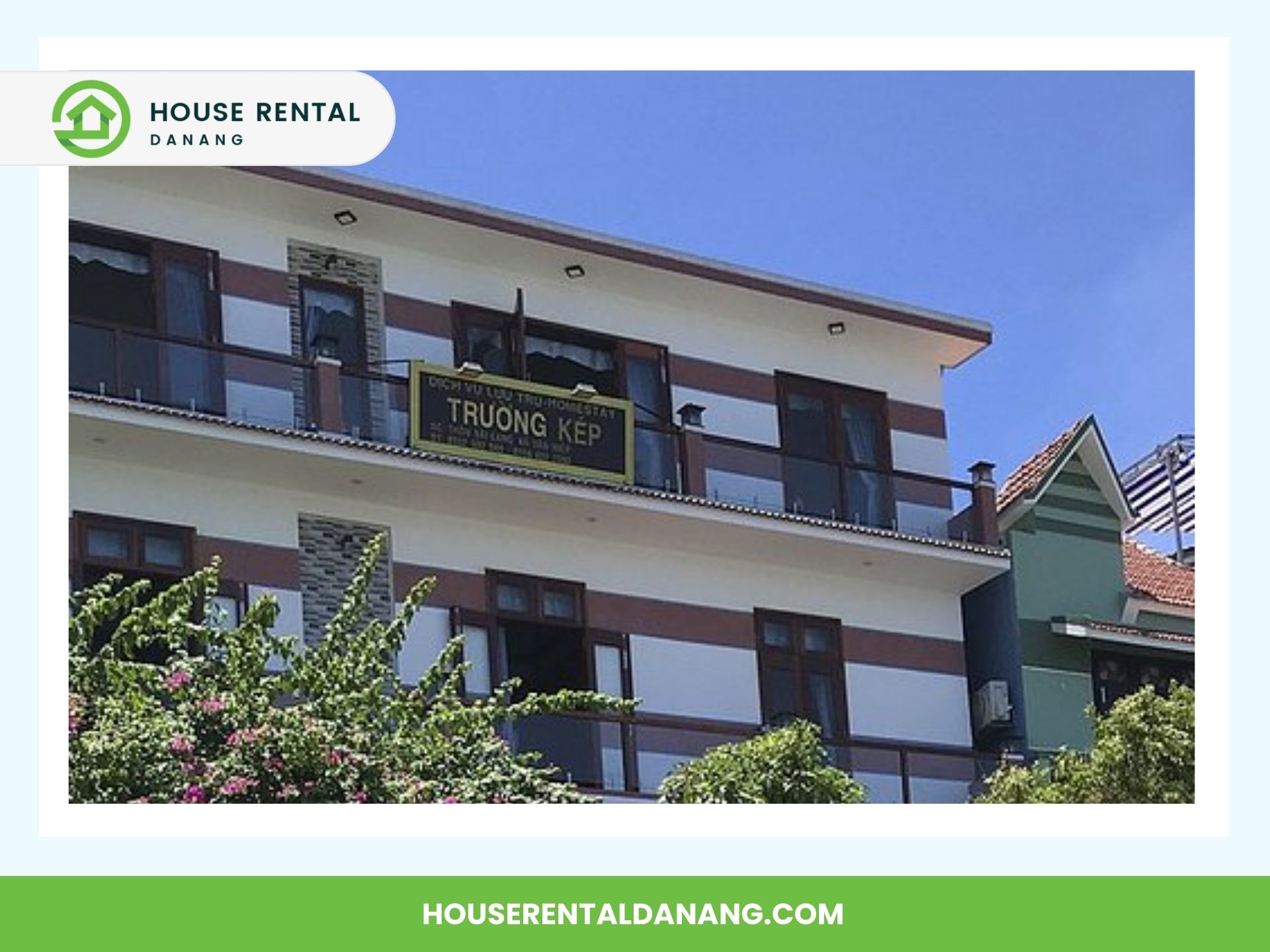 Three-story building with a sign reading "Truong Kep" on the second-floor balcony. The building has white walls with maroon accents and balconies with glass railings. Trees and shrubs are in the foreground, making it a picturesque spot for tourism near Cham Island.