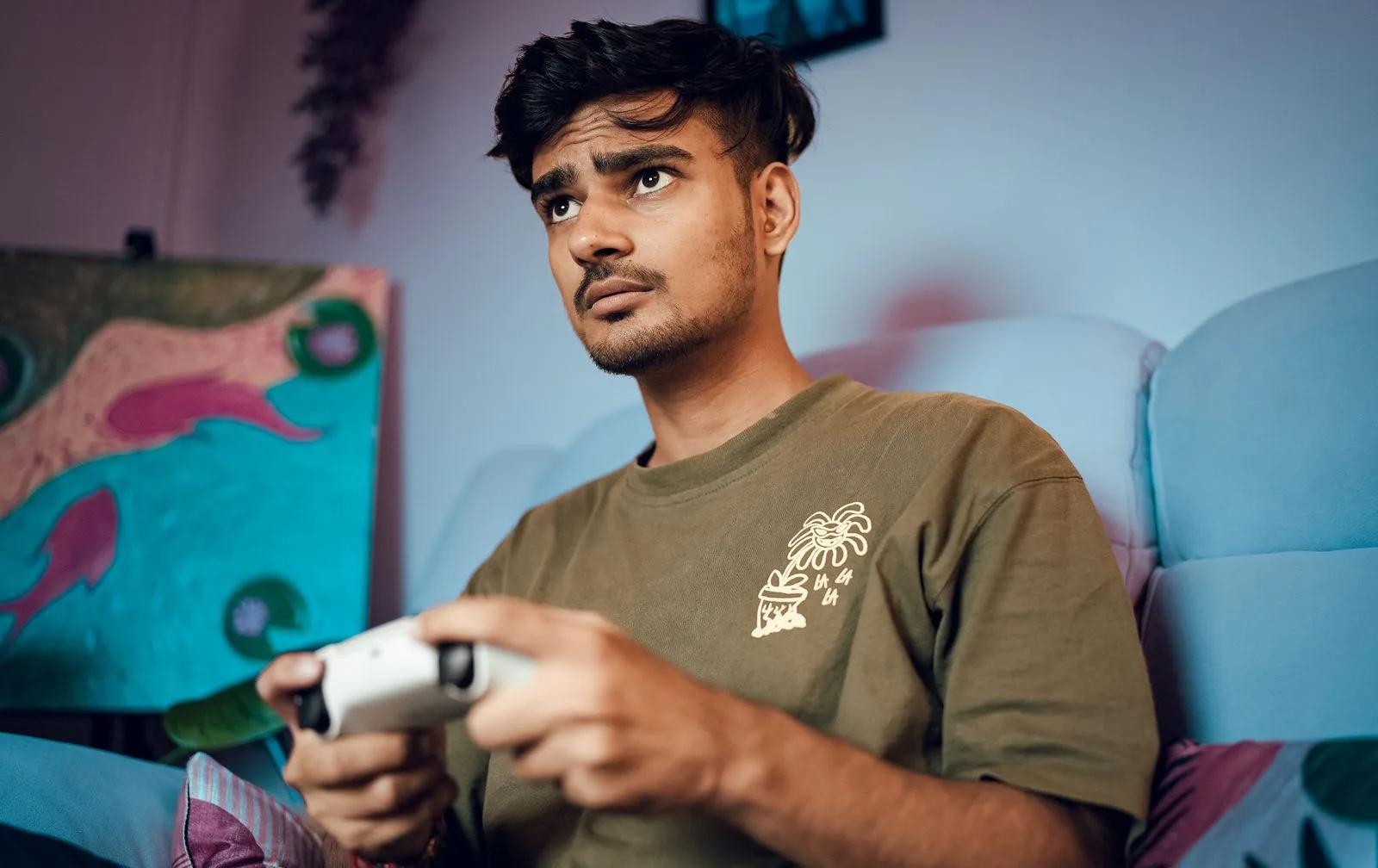 Một người đang chơi game console cầm tay cầm tại nhà