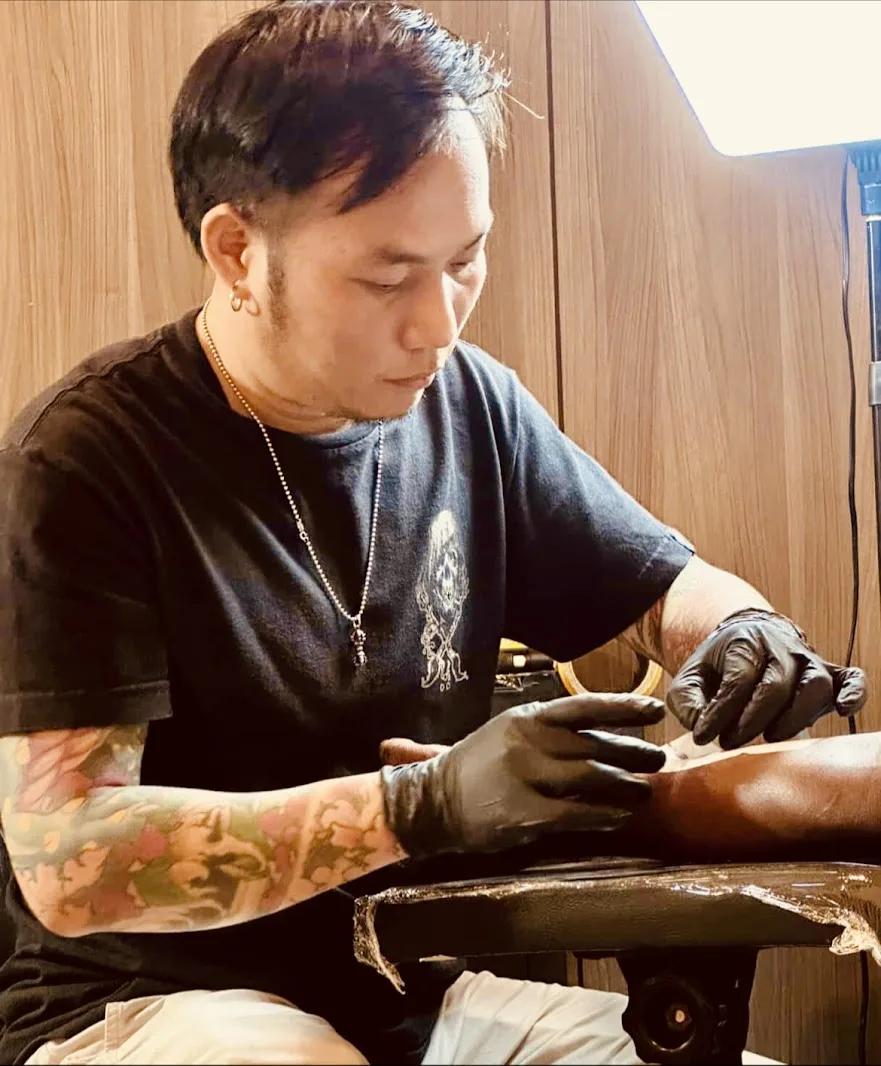 Nghệ nhân đang xăm hình cho khách bên trong studio Inker Culture Tattoo