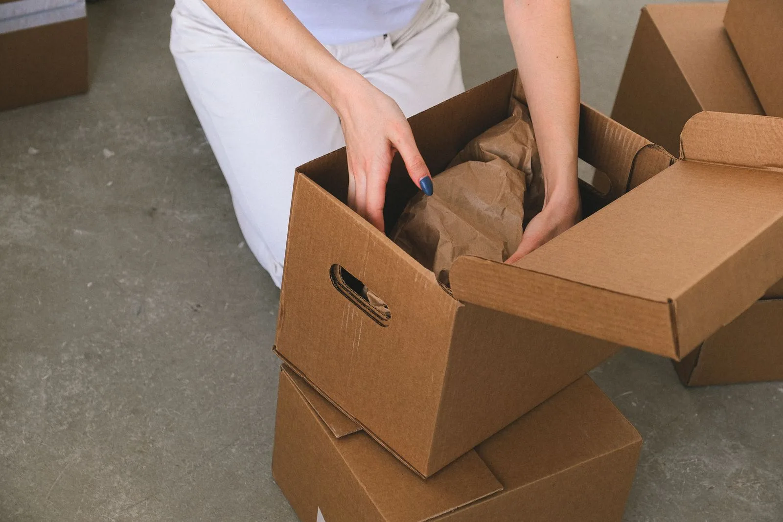 Người đang đóng đồ đạc vào thùng carton khi chuyển nhà